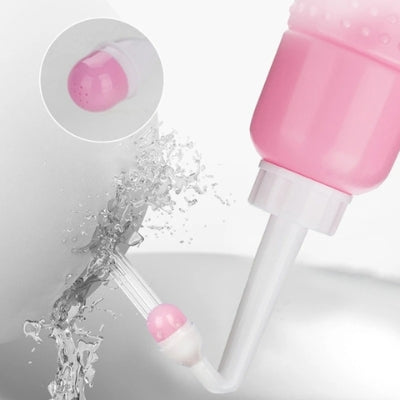 Douchette WC rose en gros plan en train de pulvériser de l'eau.