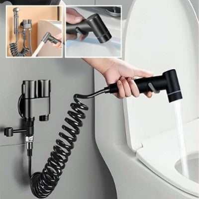 La photo nous montre une douchette WC tenue par la main d'une personne en train de nettoyer la cuvette d'une toilette.