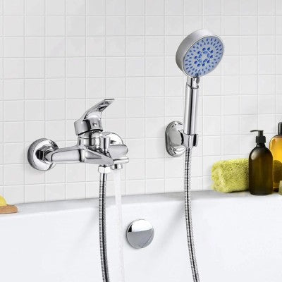 Le robinet pour baignoire et le pommeau de douche sont installés sur le mur de la salle de bain. Des bouteilles de shampoing sont posées sur le bord de la baignoire.