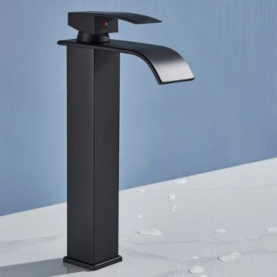 Le robinet pour lavabo noir mat long est présenté sur le pont du lavabo. On le voit incliné de face.
