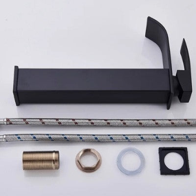 Les pièces détachées du robinet pour lavabo noir mat long sont alignées à côté du robinet qui est couché sur le côté.