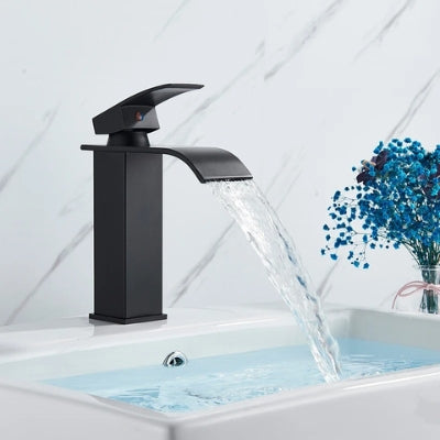 L'eau coule en cascade du robinet pour lavabo sans éclaboussures. Le lavabo est rempli jusqu'au bout.