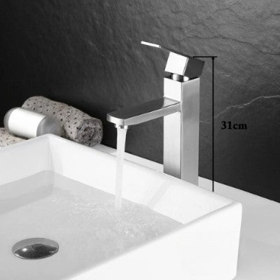 Le grand robinet nickel brossé qui mesure 31 cm avec vue de face et de l’eau qui coule dans le lavabo sans éclaboussures grâce un excellent débit d’eau.