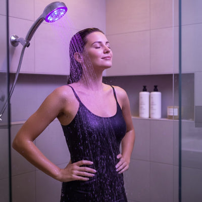 femme avec pommeau de douche seven led sous la douche